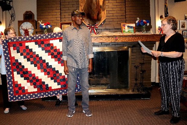 Comrade James Bates receiving his Quilt of Valor from Chris Sellman