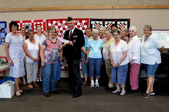 Mel Clements presents Chris Sellman of Quilts of Valor with a donation from VFW